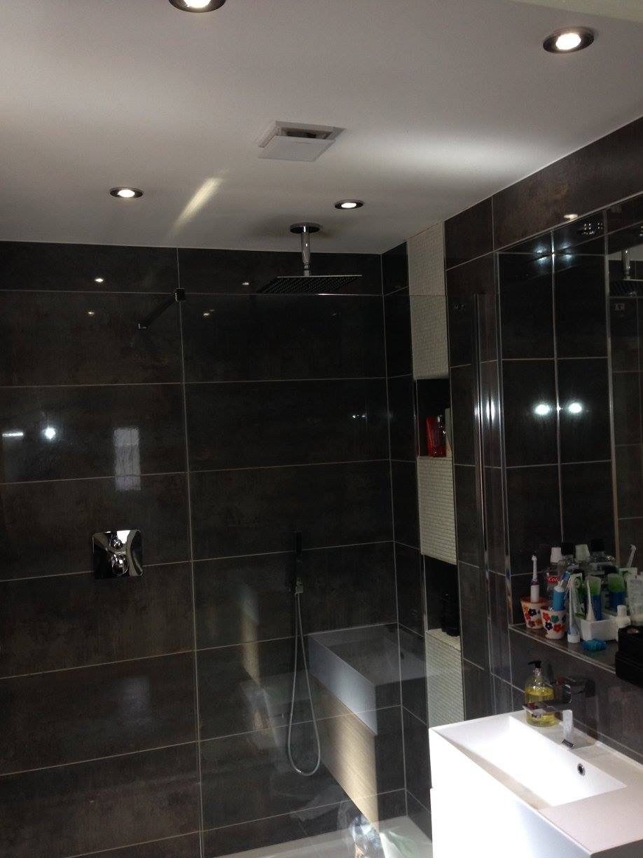Dark-tiled bathroom with downlights