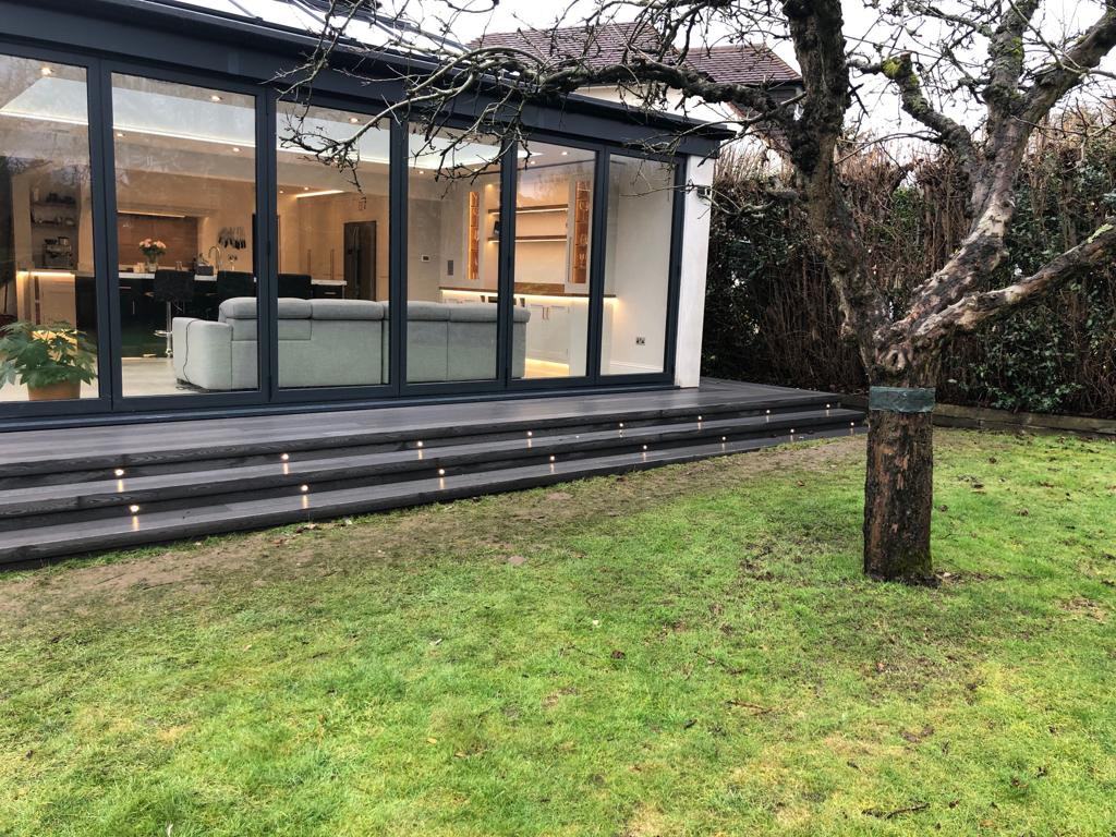 Garden decking with step lights by bifold doors